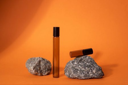 brown-glass-bottle-on-stone-on-orange-background-natural-organic-spa-cosmetic-concept-front-view-.jpg
